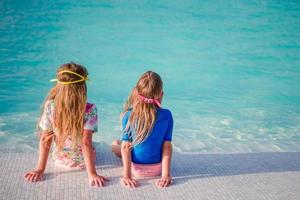 Adorable little girls in swimming pool on summer vacation photo