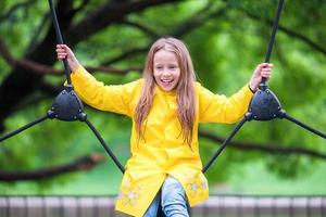 Happy little girl playng on outdoor playground photo