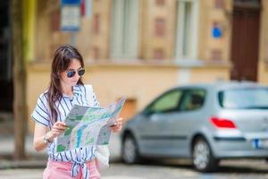 Happy young woman with a city map in Europe. Travel tourist woman with map in Prague outdoors during holidays in Europe. photo