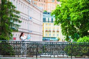 Happy young woman with a city map in Europe. Travel tourist woman with map in Prague outdoors during holidays in Europe. photo