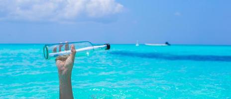 botella con un mensaje en el fondo de la mano cielo azul foto