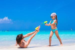 Happy father and his adorable little daughter at tropical beach having fun photo