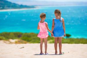 Adorable little girls having fun during beach vacation photo