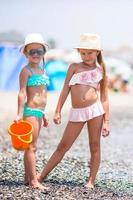 Adorable little girls having fun during beach vacation photo