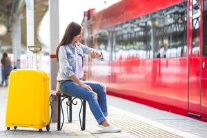 Young girl with luggage on the platform waiting for Aeroexpress photo