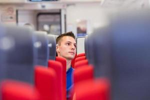 Young happy man traveling by train photo