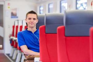 Young happy man traveling by train photo