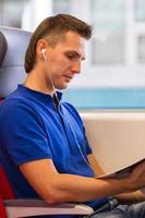 Young happy man listening music traveling by train photo