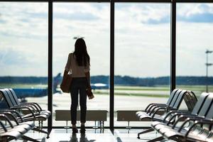 silueta de mujer en un salón del aeropuerto esperando el avión de vuelo foto