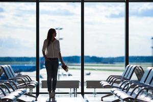 silueta de un pasajero de una aerolínea en un salón del aeropuerto esperando un avión de vuelo foto