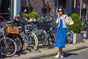 Young caucasian woman talking by cell phone in european city photo