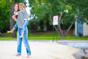 Happy mom and adorable little girl enjoying summer vacation photo