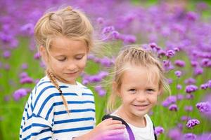 niñas adorables caminando al aire libre con flores foto