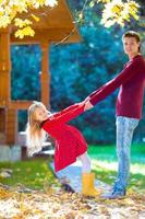 adorable niña con padre en el parque de otoño al aire libre foto