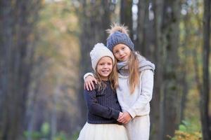 Little adorable girls outdoors at warm sunny autumn day photo