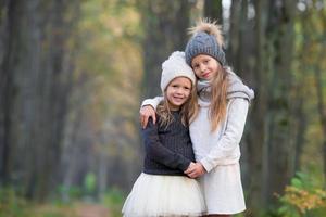 Little adorable girls outdoors at warm sunny autumn day photo