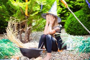 adorable niña con traje de bruja en halloween al aire libre. truco o trato. foto