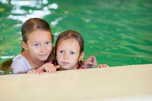 adorables niñas en la piscina en vacaciones de verano foto