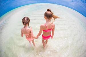 Adorable little girls at beach during summer vacation photo