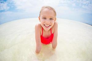 Adorable little girl during beach vacation having fun photo