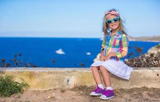 Adorable little girl have fun outdoor with beautiful view photo