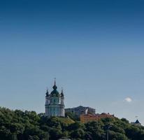 Beautiful church on a mountain with trees against a blue sky background photo