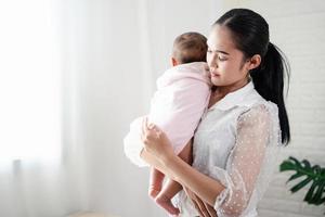 Mother Parenting and newborn birth life. Mom and baby boy playing in sunny bedroom, Family having fun together. childcare, maternity concept. photo