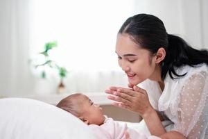 Mother Parenting and newborn birth life. Mom and baby boy playing in sunny bedroom, Family having fun together. childcare, maternity concept. photo