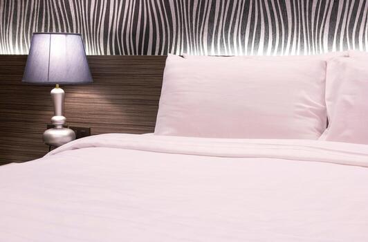 lámpara de mesa con dormitorio en la habitación del hotel foto