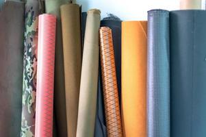 rollos de telas y textiles naturales de alta costura puestos en el taller de costura. concepto de la industria de la costura foto