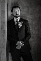 portrait of a male groom in a blue suit in the morning  barbershop photo