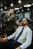 bearded man cutting his beard in the barbershop photo