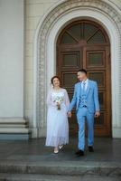 novia con un vestido de novia ligero al novio con un traje azul foto