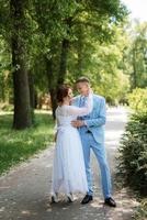 bride in a light wedding dress to the groom in a blue suit photo