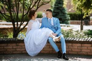 bride in a light wedding dress to the groom in a blue suit photo