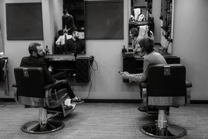 bearded man cutting his beard in the barbershop photo