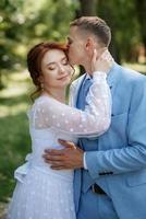 bride in a light wedding dress to the groom in a blue suit photo