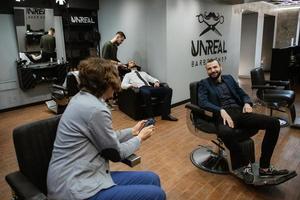 hombre barbudo cortándose la barba en la barbería foto