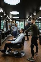 bearded man cutting his beard in the barbershop photo