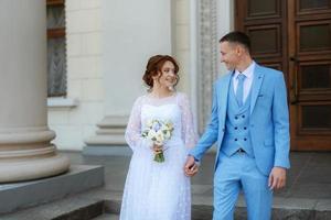 novia con un vestido de novia ligero al novio con un traje azul foto