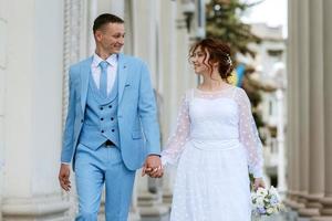 novia con un vestido de novia ligero al novio con un traje azul foto