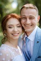 bride in a light wedding dress to the groom in a blue suit photo