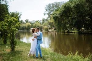 novia con un vestido de novia ligero al novio con un traje azul foto