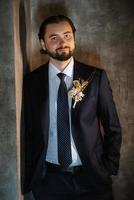 portrait of a male groom in a blue suit in the morning  barbershop photo
