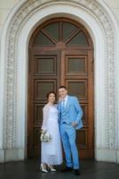 bride in a light wedding dress to the groom in a blue suit photo