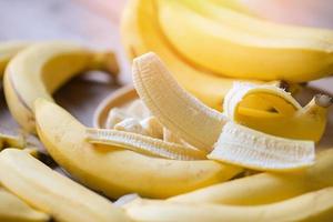 cáscara de plátano sobre fondo amarillo, fruta madura de cáscara de plátano en el suelo - racimo de plátanos foto