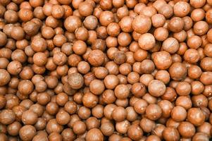 macadamia nuts texture background, fresh natural shelled raw macadamia nuts in a full frame, close up pile of roasted macadamia nut - top view photo