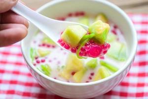 Thai dessert - Thai rice flour pandan leaf cantaloupe jelly mixed fruit with coconut milk and syrup sweets dessert on bowl, Asian food photo