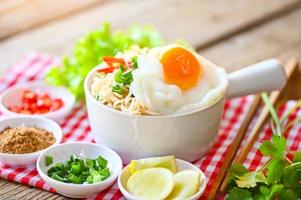 noodles bowl with boiled egg vegetable spring onion lemon lime lettuce celery and chili on wooden table food , instant noodles cooking tasty eating with bowl - noodle soup photo