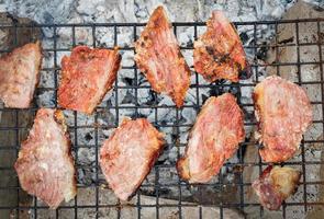 filetes de cerdo a la parrilla, cuello de cerdo con sal a la parrilla naturaleza comida local rural asia, carne a la parrilla barbacoa cerdo asado comida callejera foto